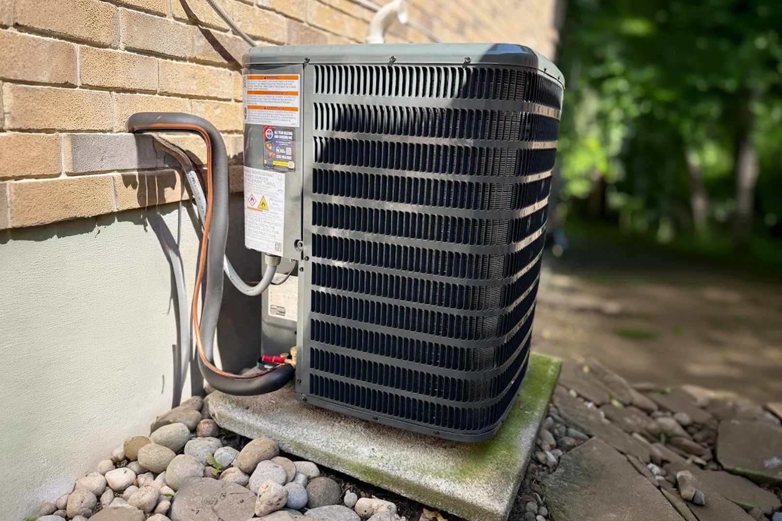 Goodman central AC condenser unit installation on concrete pad in Waterloo.