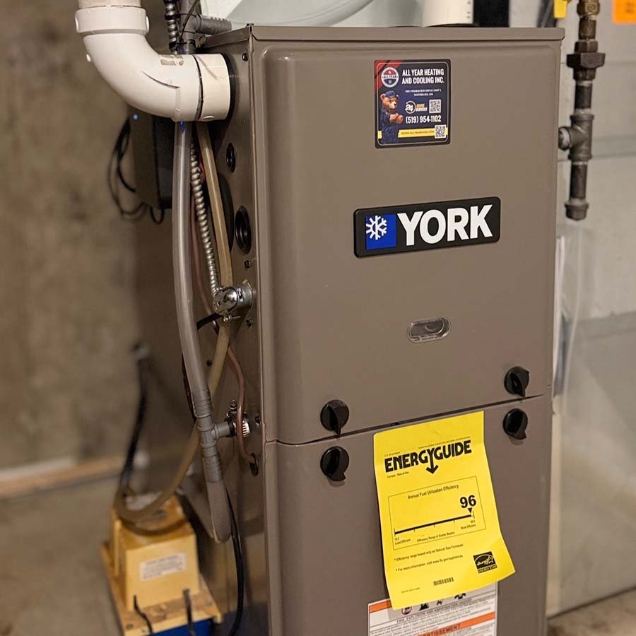 Close-up view of a professional furnace installation in a Waterloo home, highlighting the gas line connections and safety features.